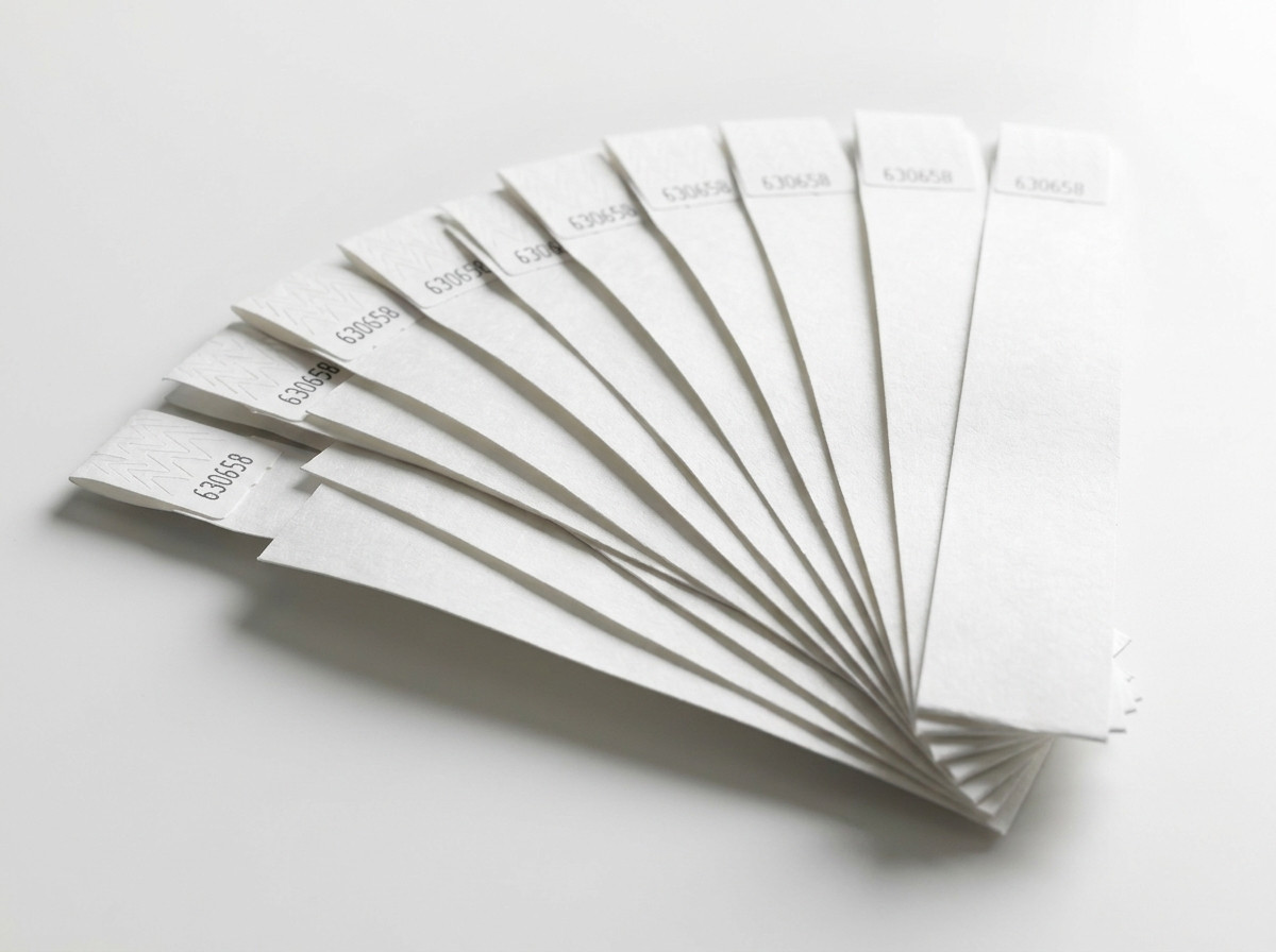 Conjunto de pulseras de plástico rígido blanco dispuestas en abanico, listas para distribuir